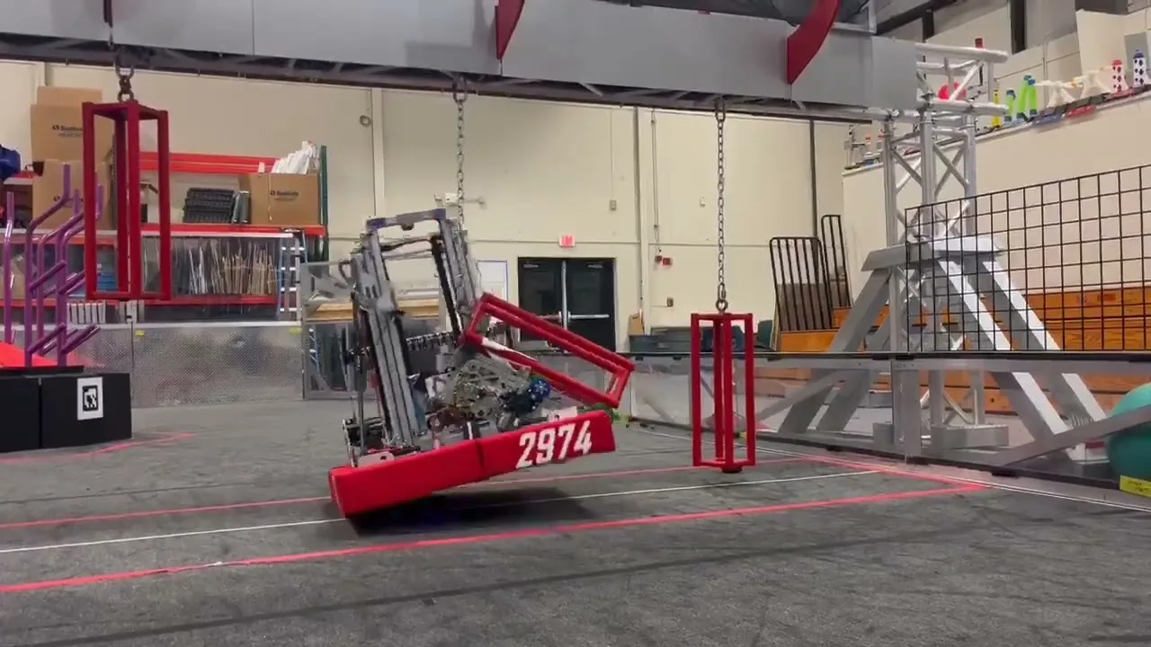 Robot hanging at an angle from the practice cage during an early climber test
